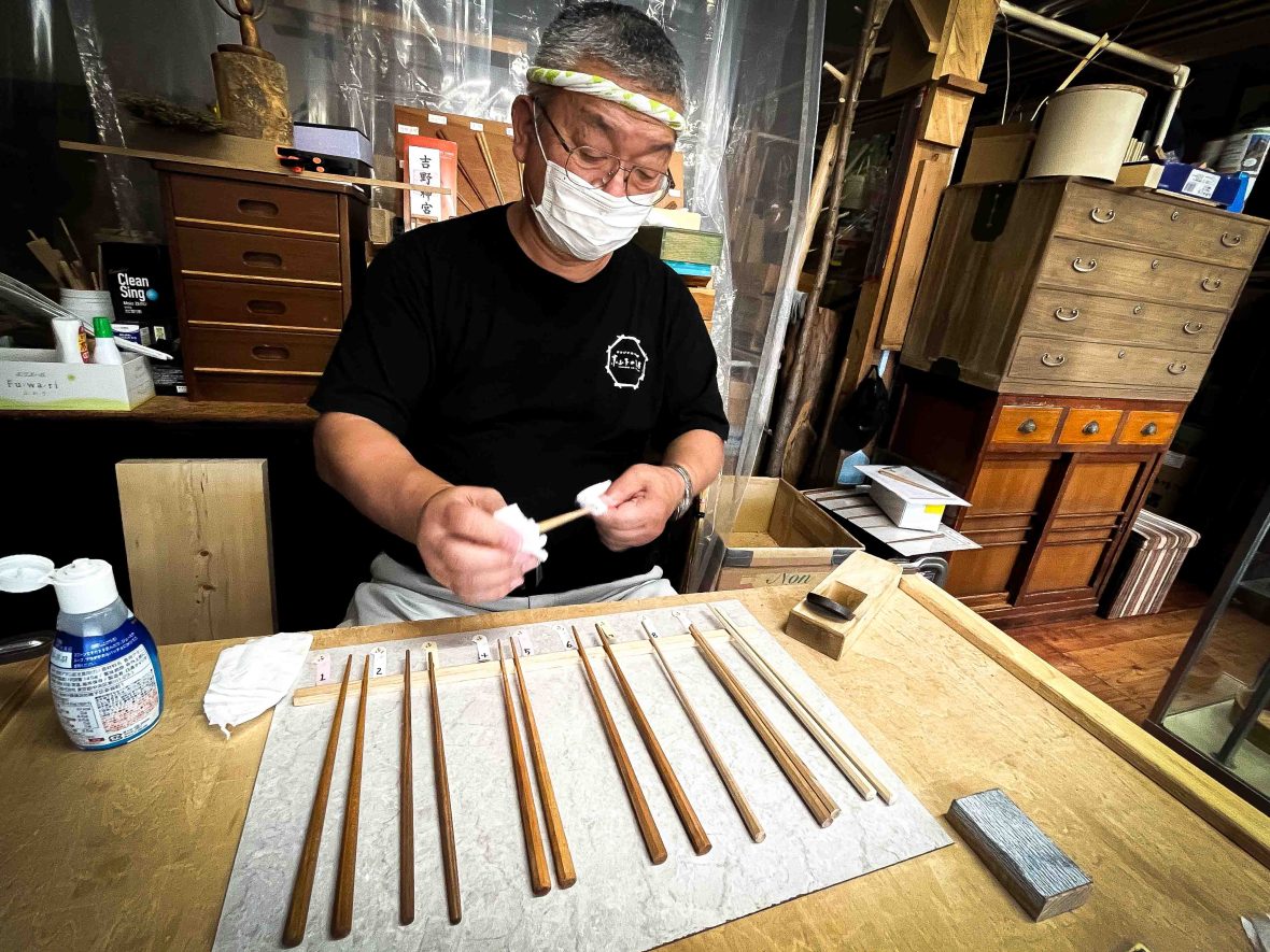 A man makes chopsticks.