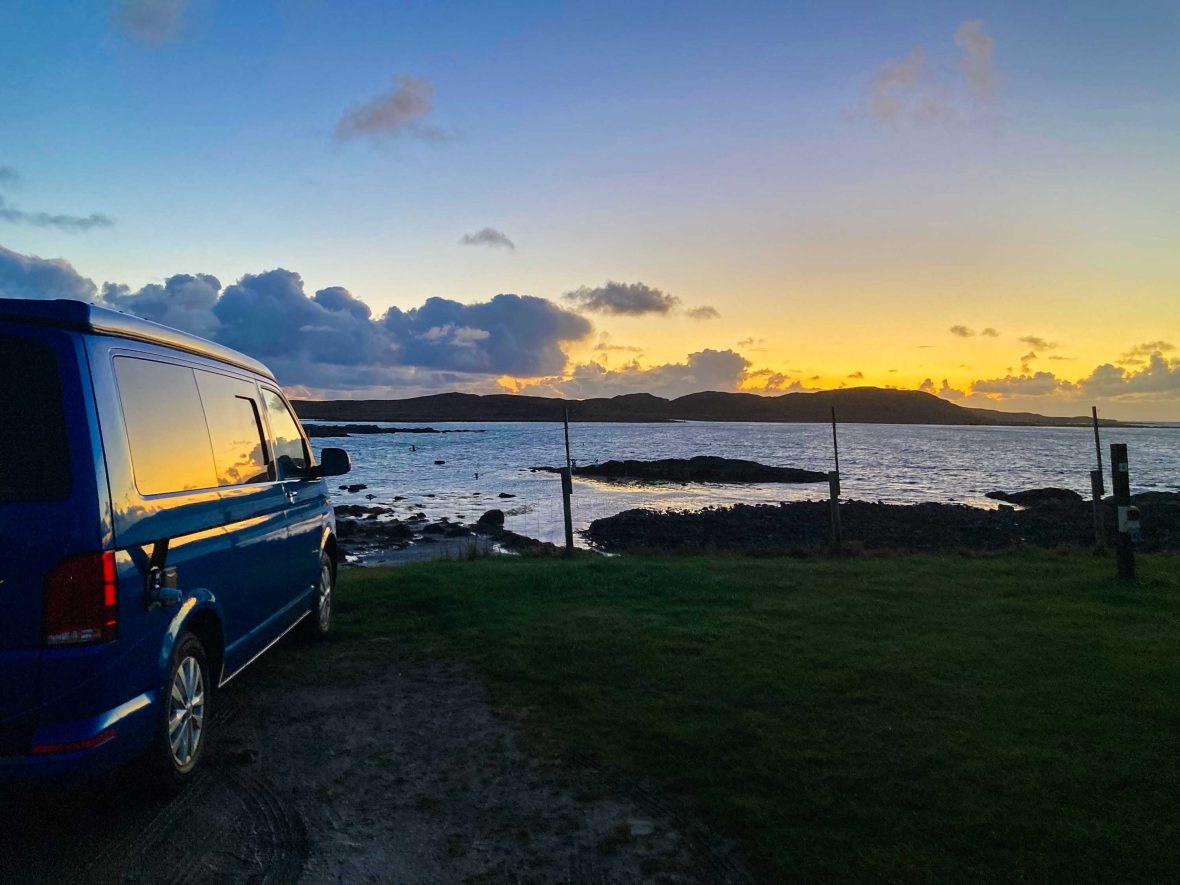 A van is parked with a view of a sunset.