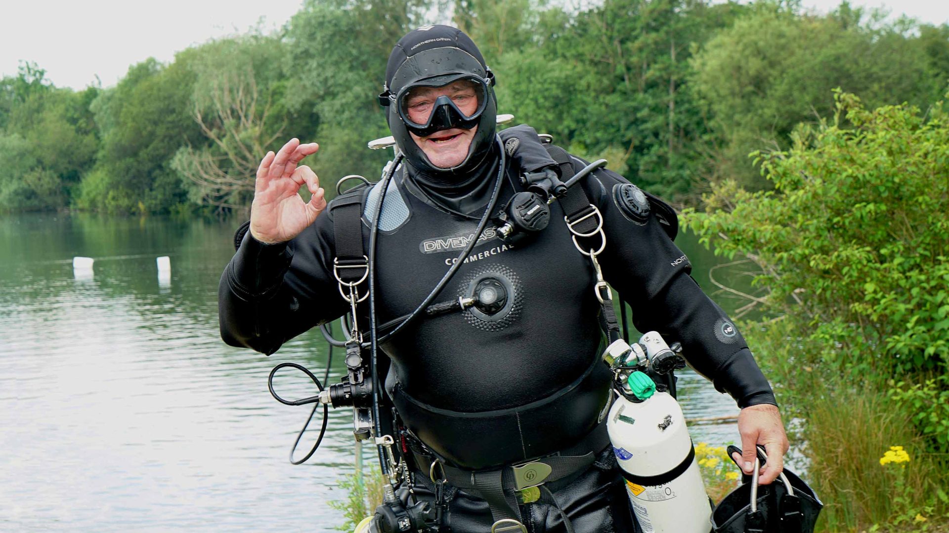 Alastair in scuba diving gear by a river.