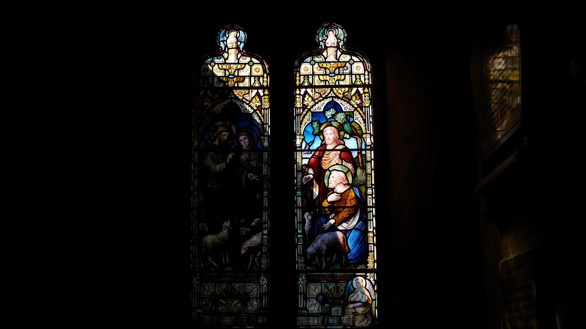 Light falls onto the stained glass windows of a church.