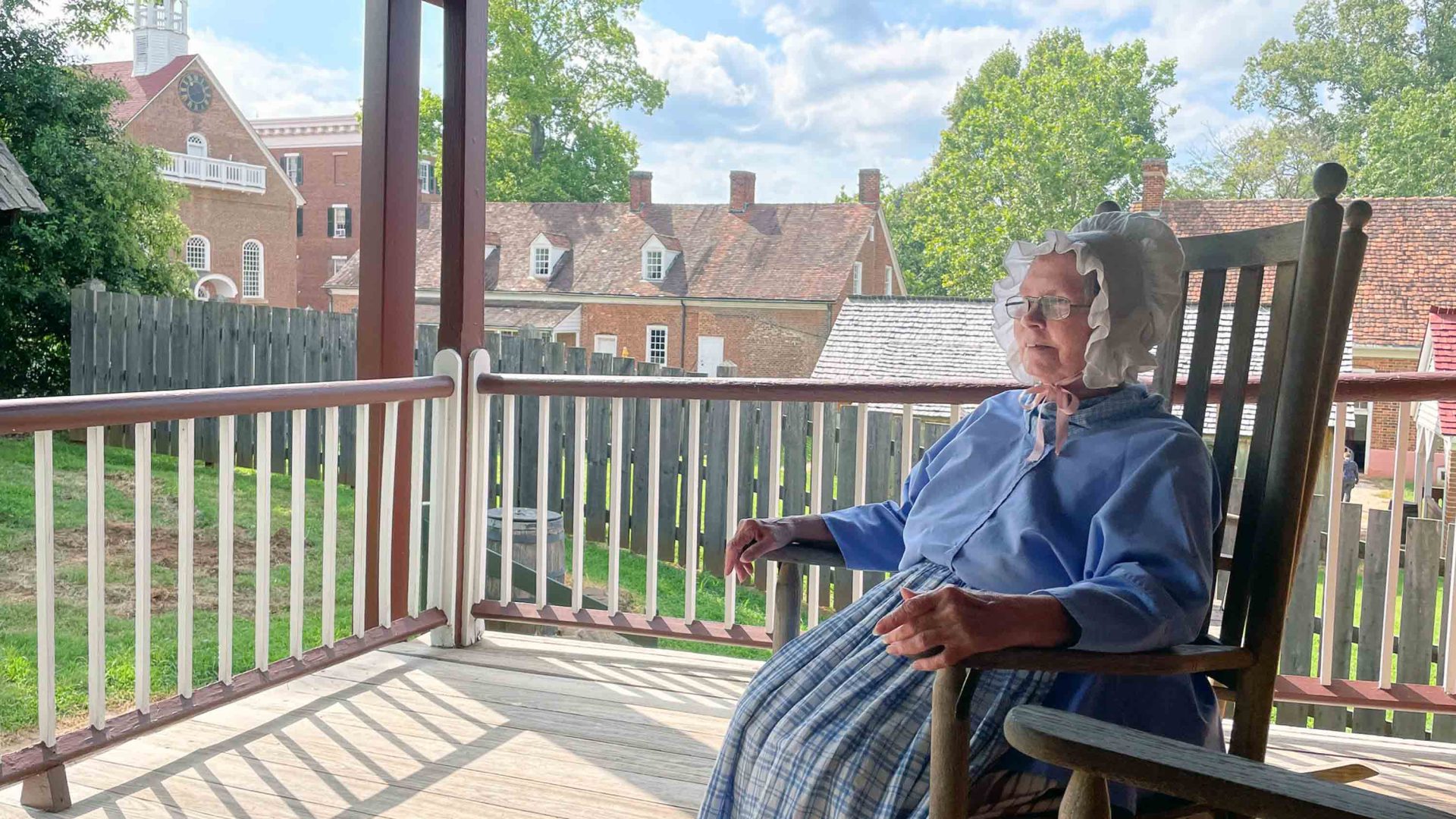 Sister Deb on Winkler Bakery porch in a rocking chair.