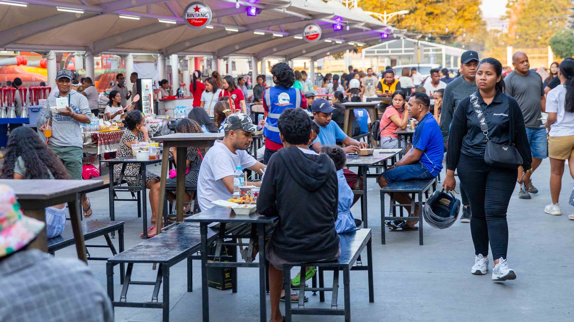 People sit and eat and stroll around Timor Plaza for its Saturday night market.