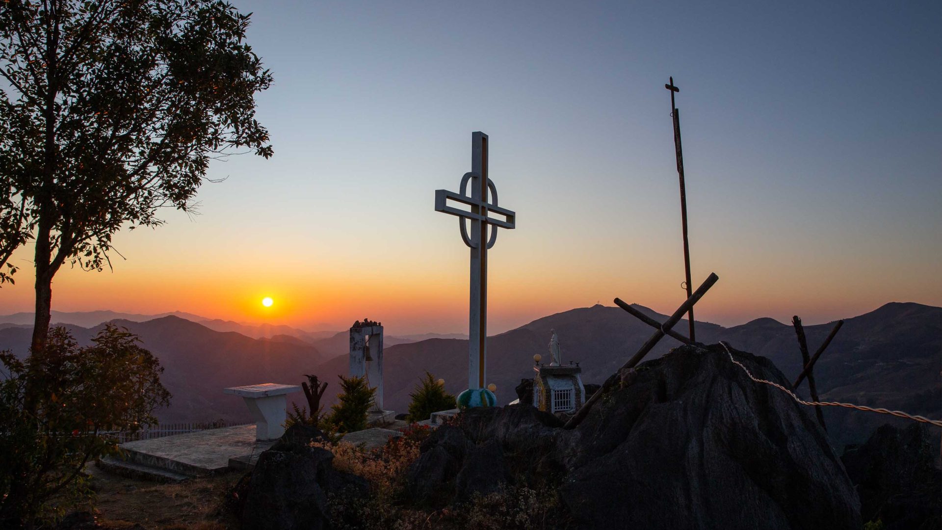 A cross on a hill at dusk.