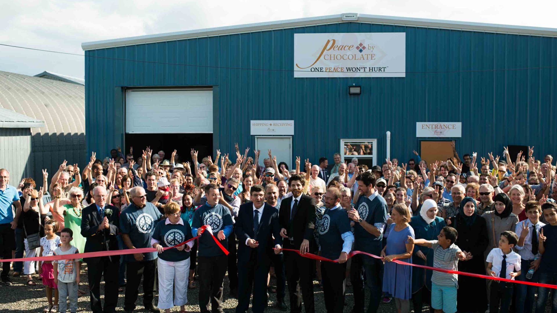 Surrounded by family and community, Isam and Tareq Hadhad cut the ribbon at the grand opening of the Peace by Chocolate factory.