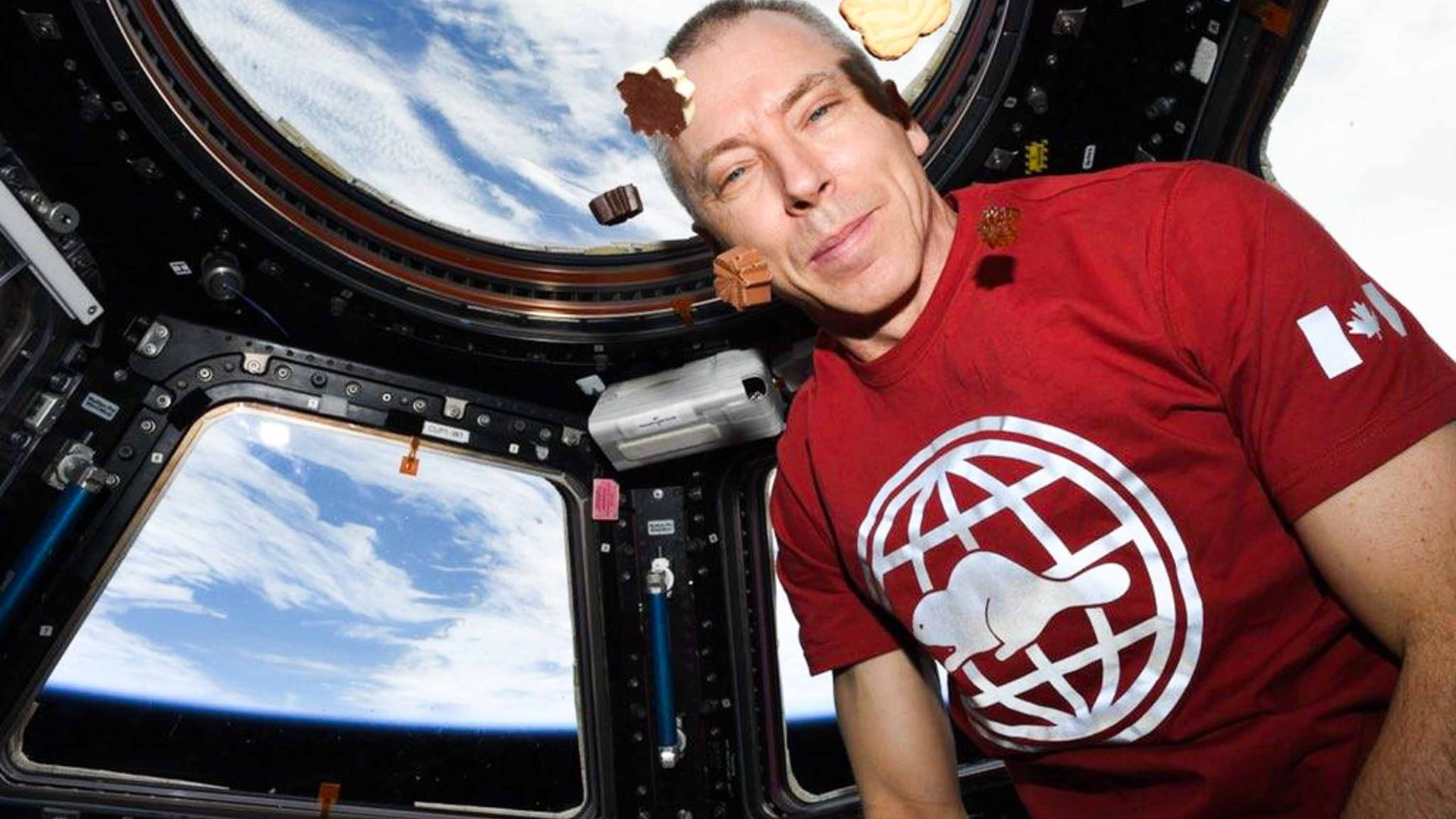 Chocolates floating round the face of someone on the International Space Station.