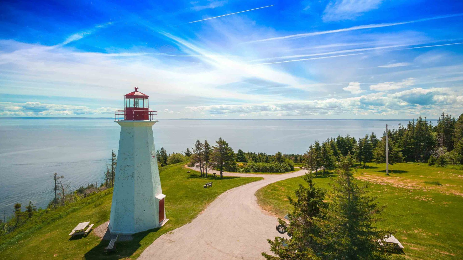 A path winds past a coastal lighthouse.