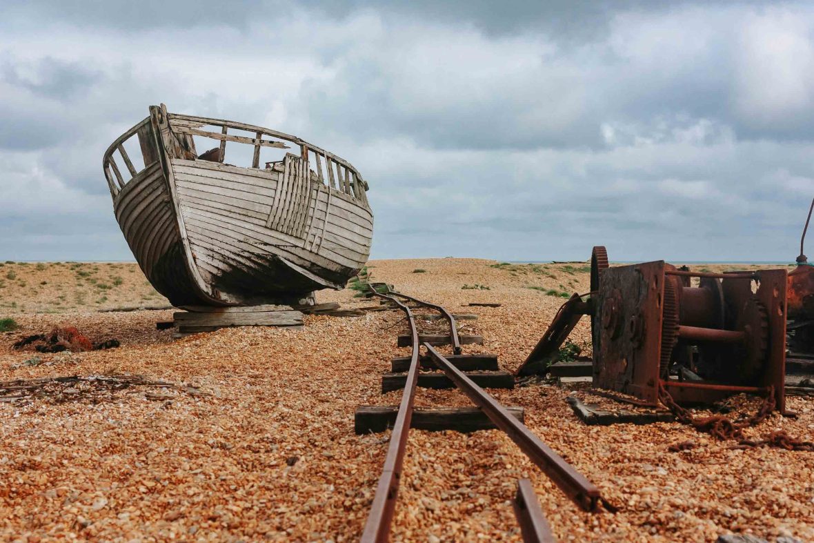 An old boat and old train tracks in the sand at Dungeness.