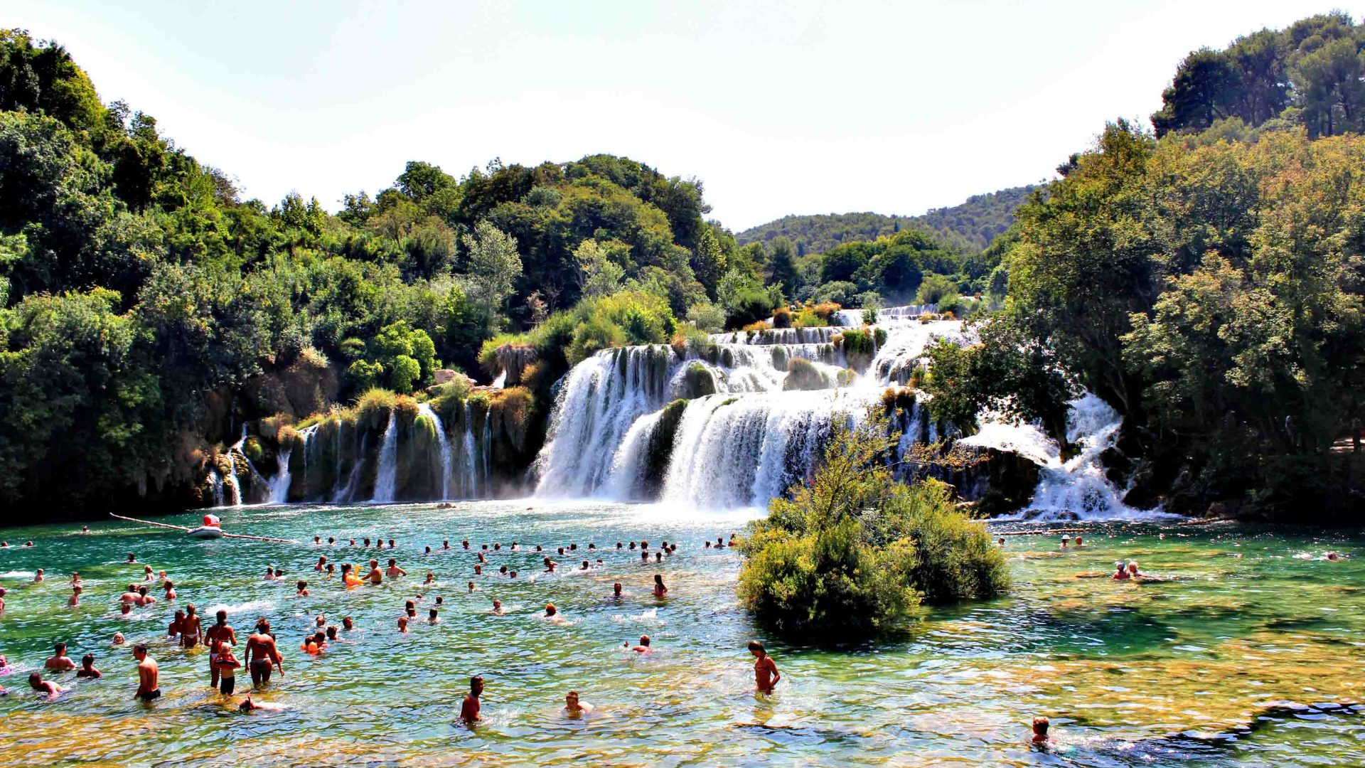 The waterfall Skradinski Buk with tourists swimming in the water.