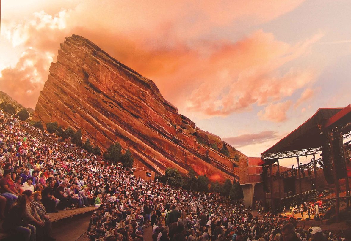 Red Rocks amphitheatre in the soft afternoon light with a large audience.