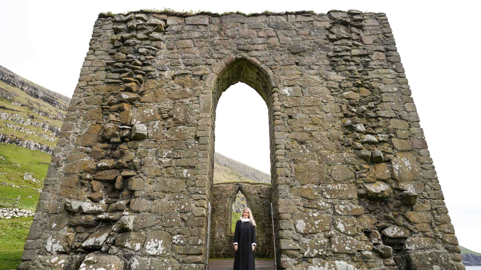 Steintóra Poulsen, a 30-year-old priest in the Faroe Islands, outside of the ruins of St Magnus Cathedral. She wears black and white.
