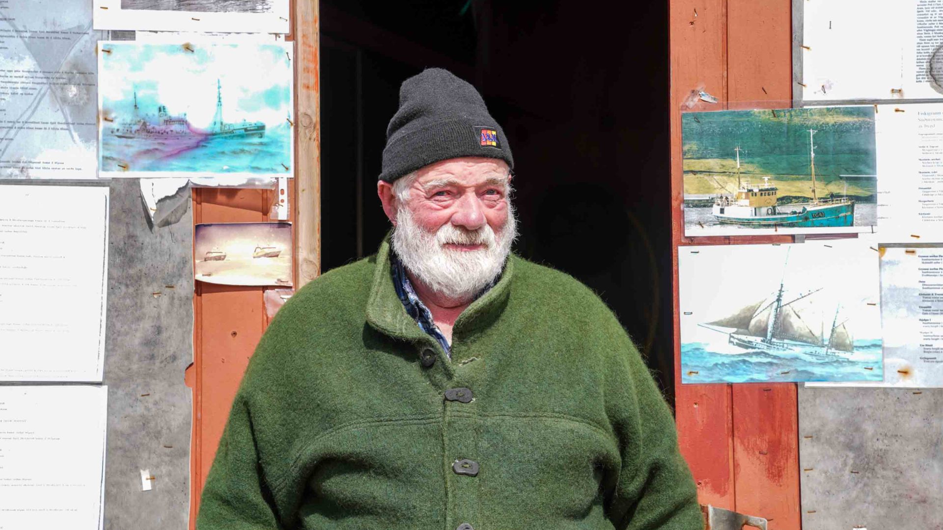a portrait of an older man with a white beard and wearing a beanie on his head.