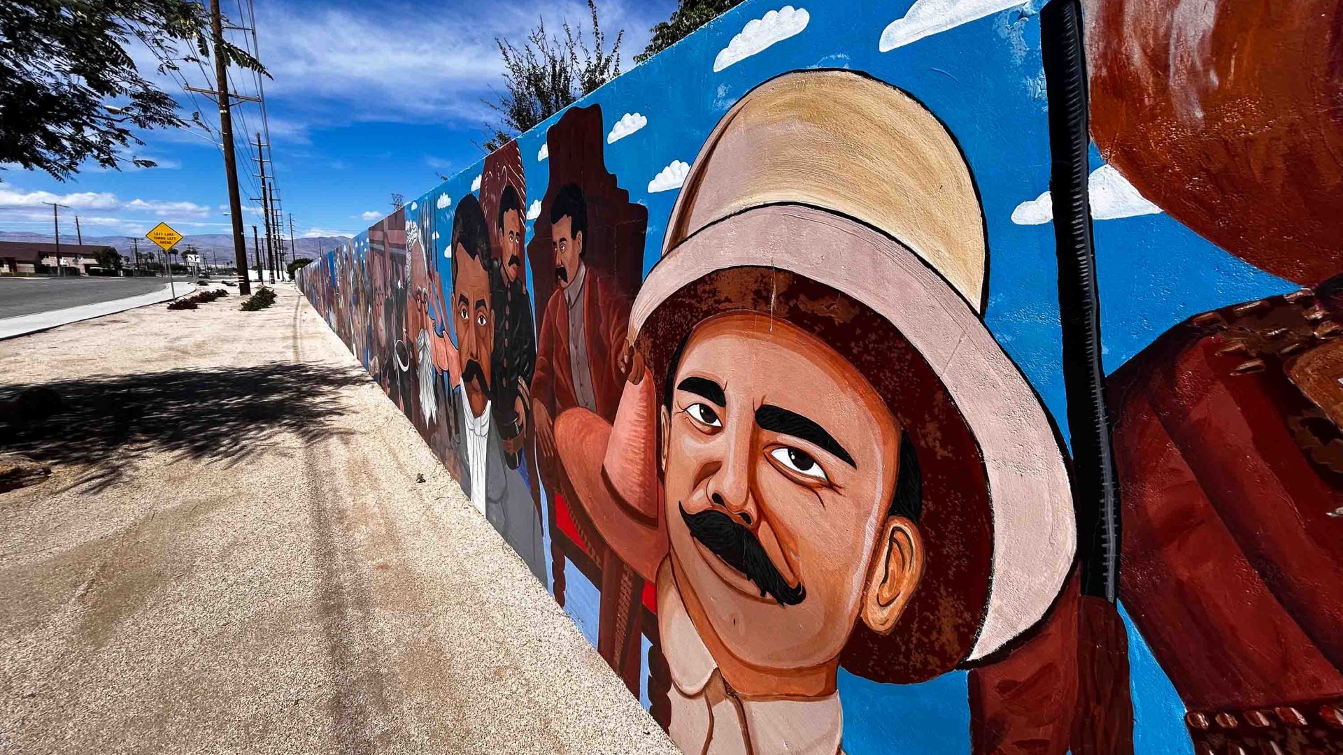 A long mural stretches along the street.