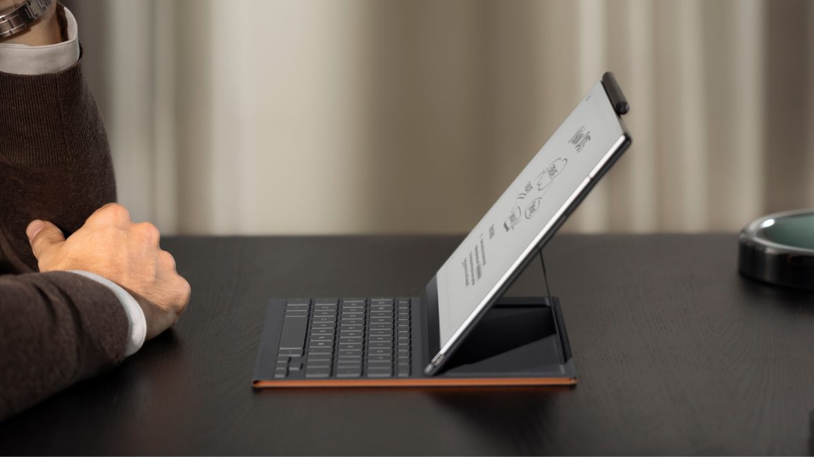 Side view of a person using the reMarkable e-ink tablet with keyboard