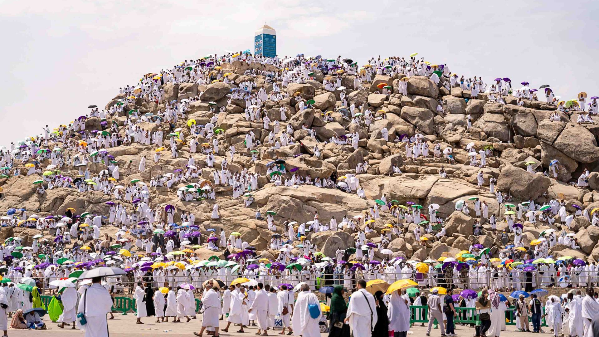 Hundreds of people in white ascend a mountain.