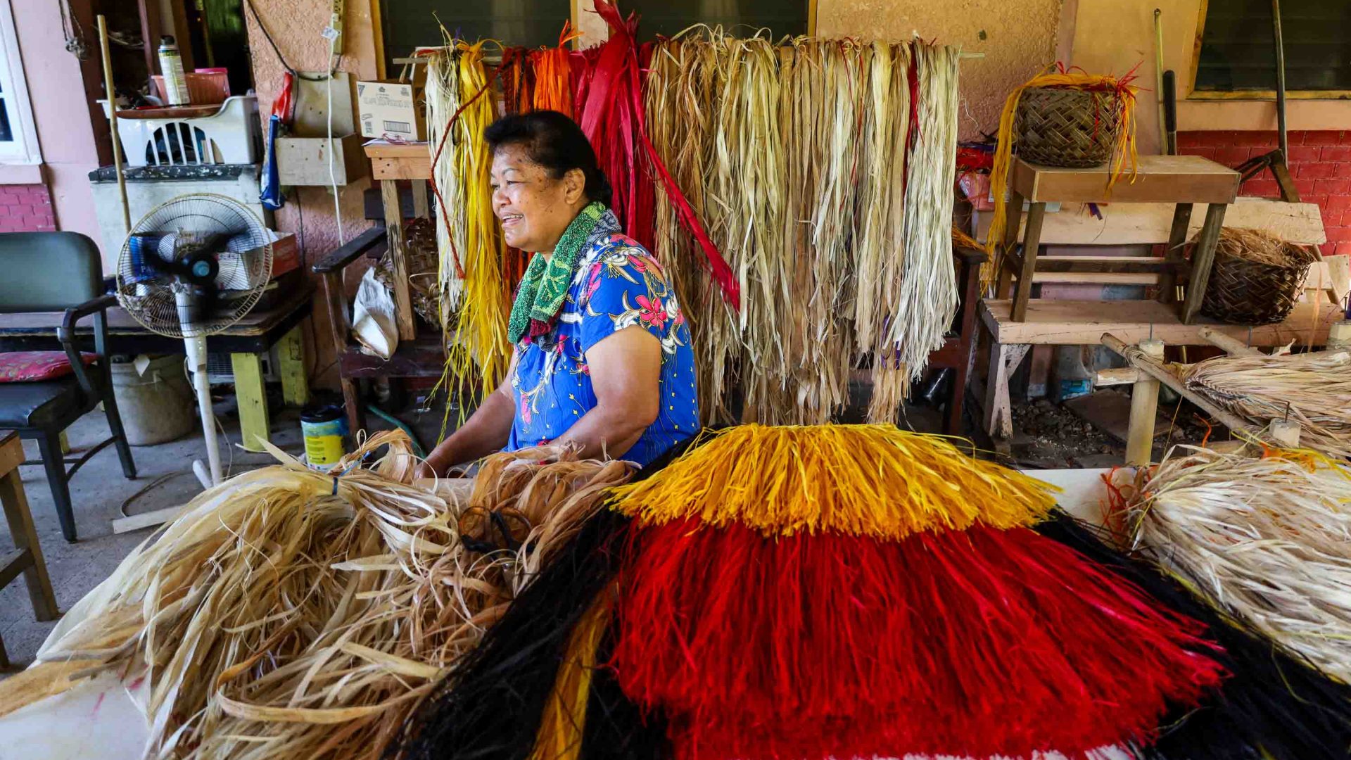 A woman sits with the hibiscus bark needed to make the traditional skirts worn in Palau.