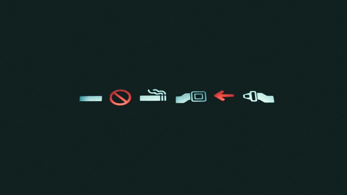 A black graphic showing the lit-up no-smoking and seatbelt sign on an airplane