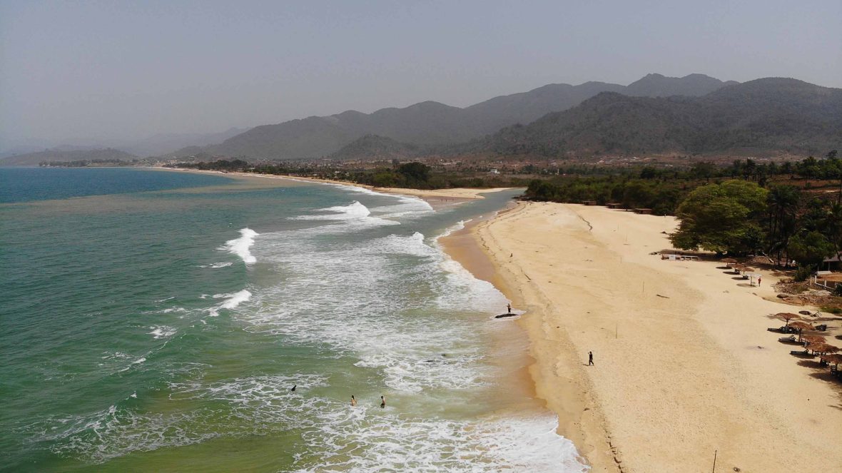 Looking down at the sand, ocean and mountains of Bureh Beach.