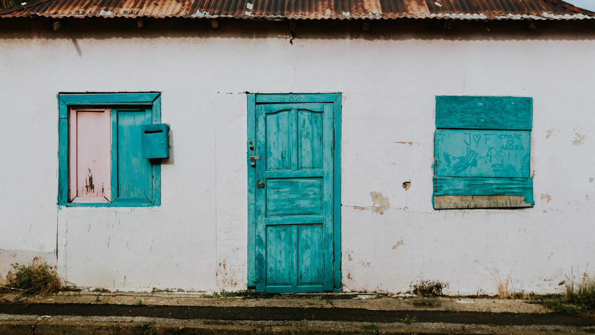 white washed building with blue doors and windows