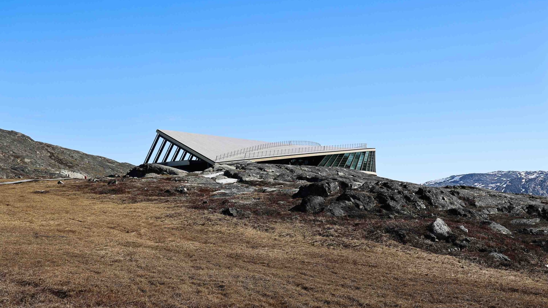 The Icefjord Centre sits on arid ground with a sloped roof.