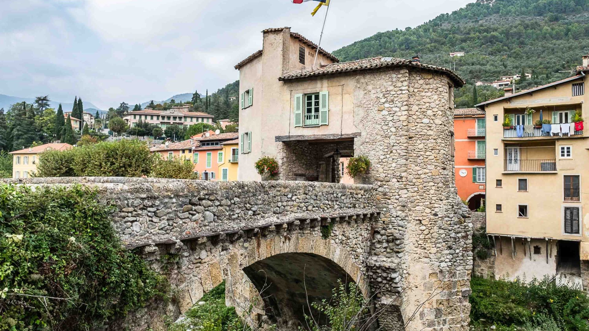 A bridge leads to a tower with a flag on it.