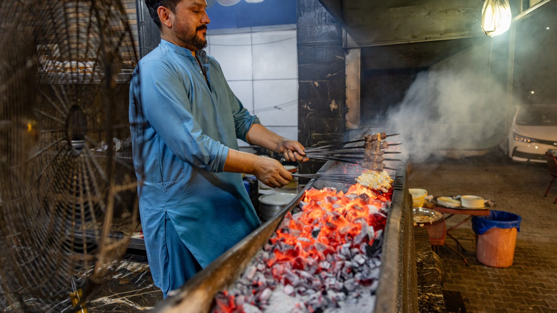 A chef cooks over an open fire.