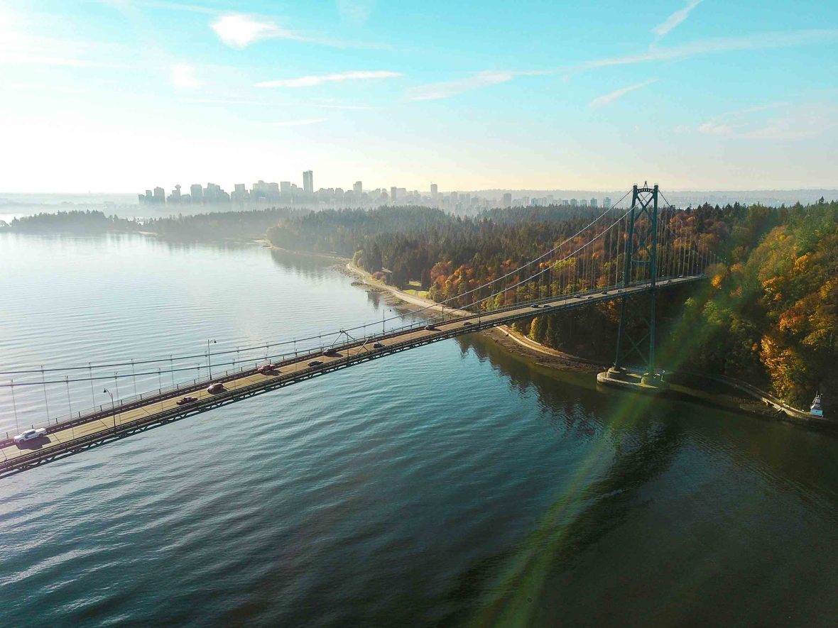 A bridge crosses the water. City and trees are on one side.