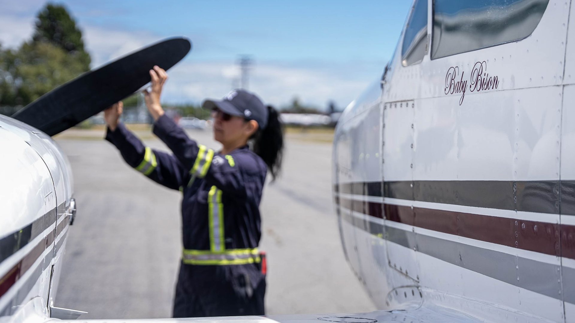 A woman loads something onto a small plane.