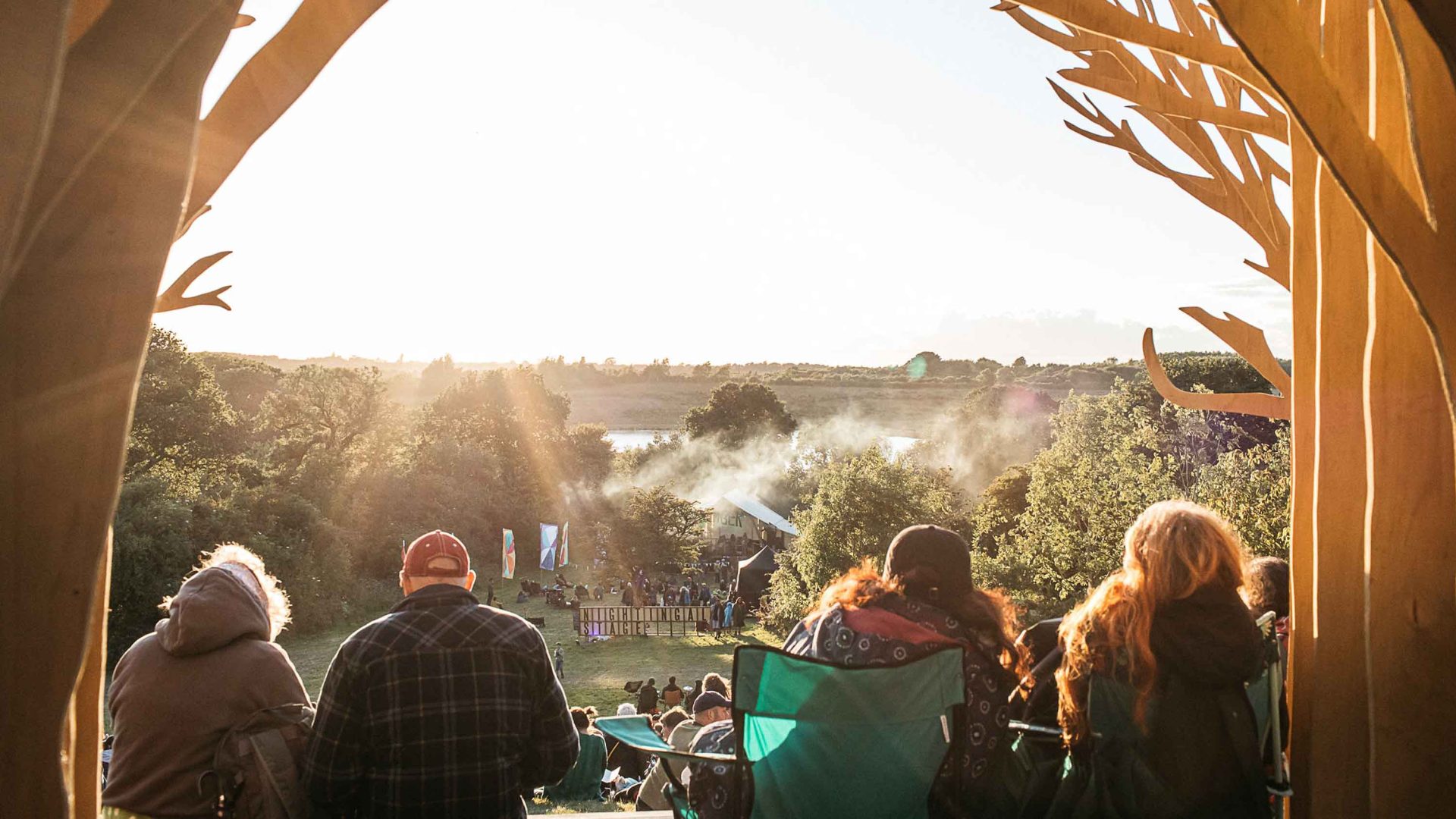 People sit and look out at a field of the festival.