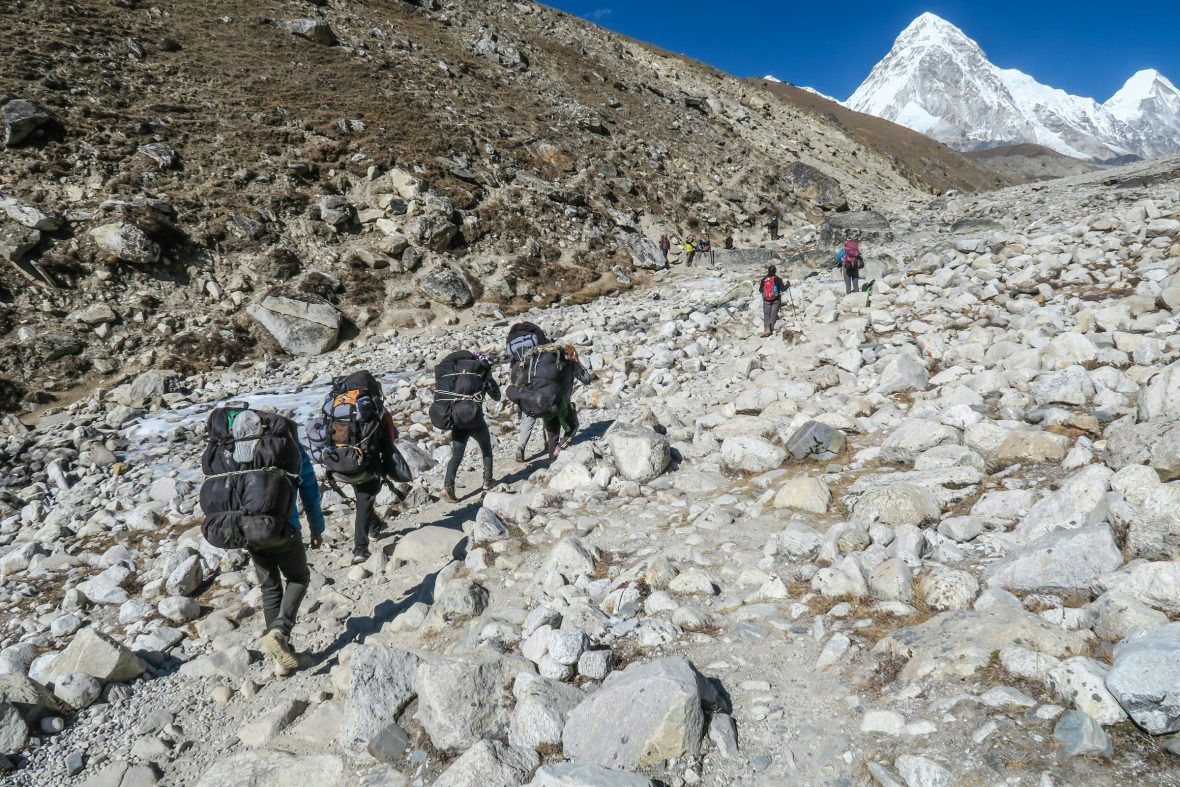 A group of hikers trek along the rocky terrains in the Himalayas