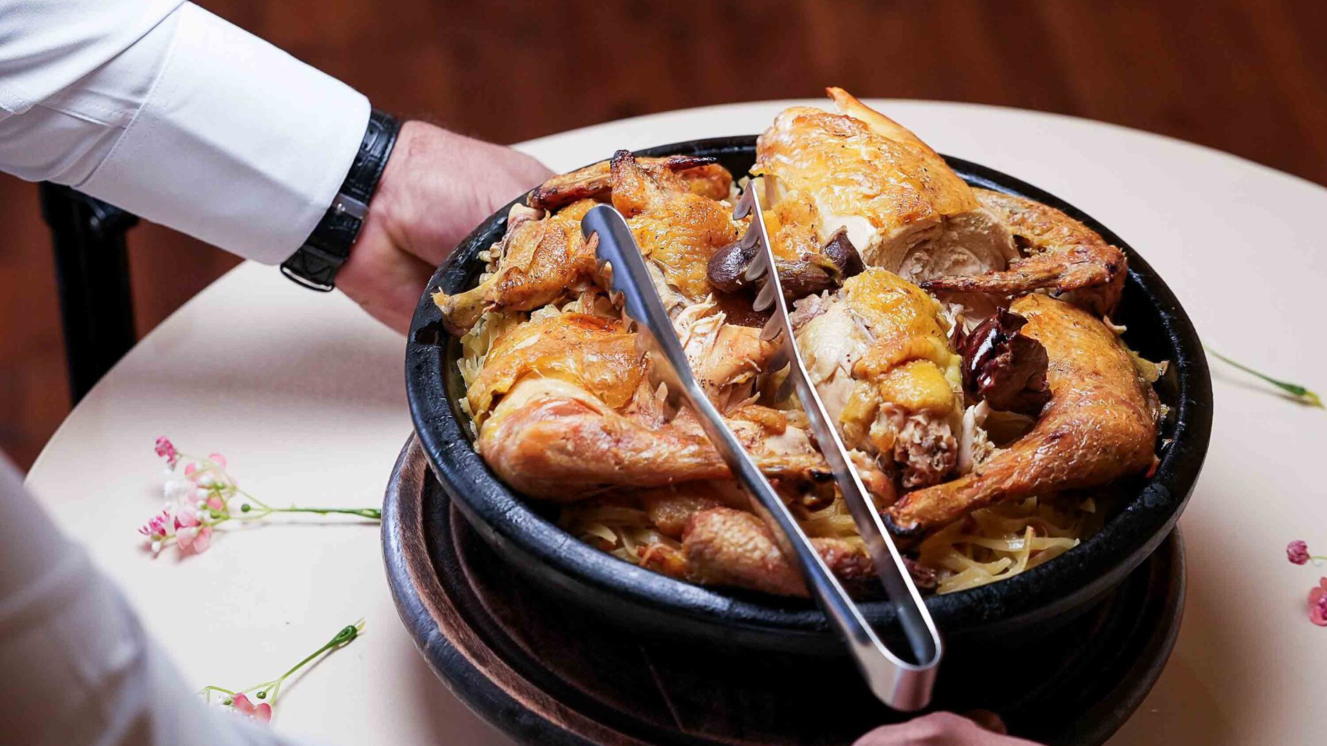 A waiter serves up some chicken and pasta.