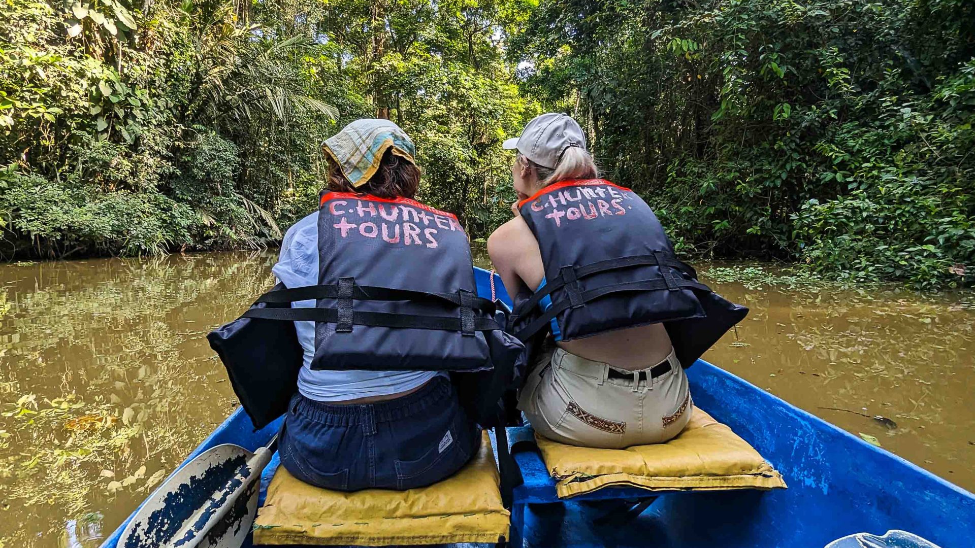 Two women travel by small boat down the river