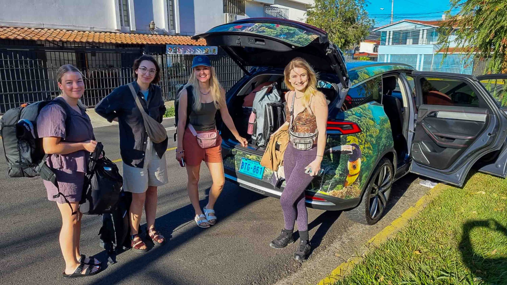 Nancy, Lydia, Hannah and Monica stand in front of the electric vehicle they used to travel in Costa Rica.