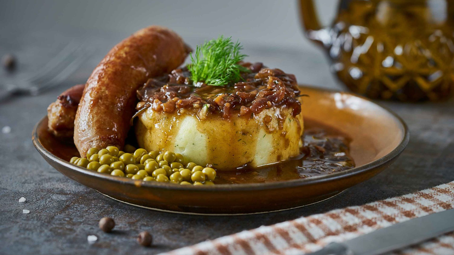 Photo: A plate of mash potato, sausage and peas.