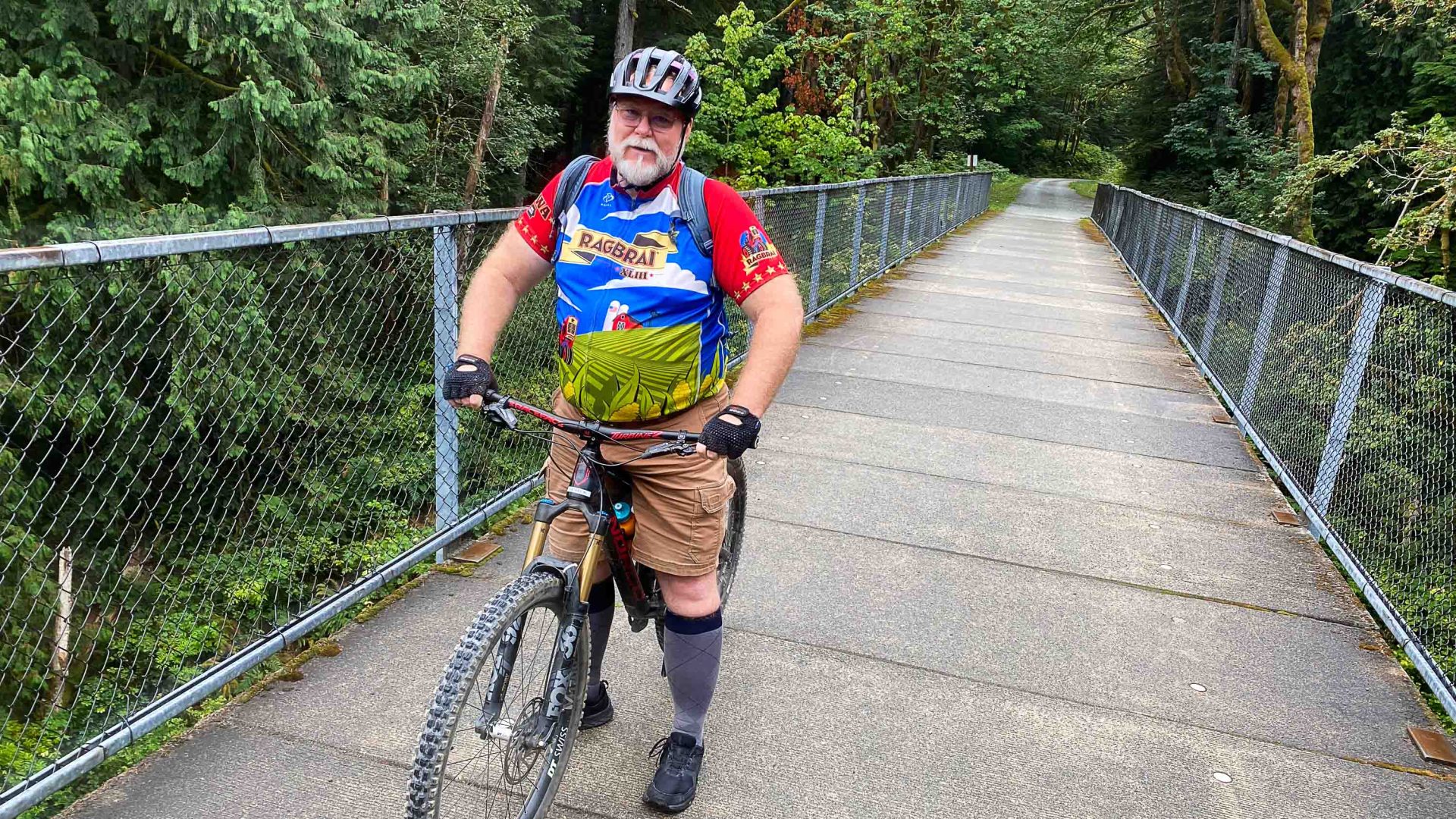 A man on his bike on a bridge.