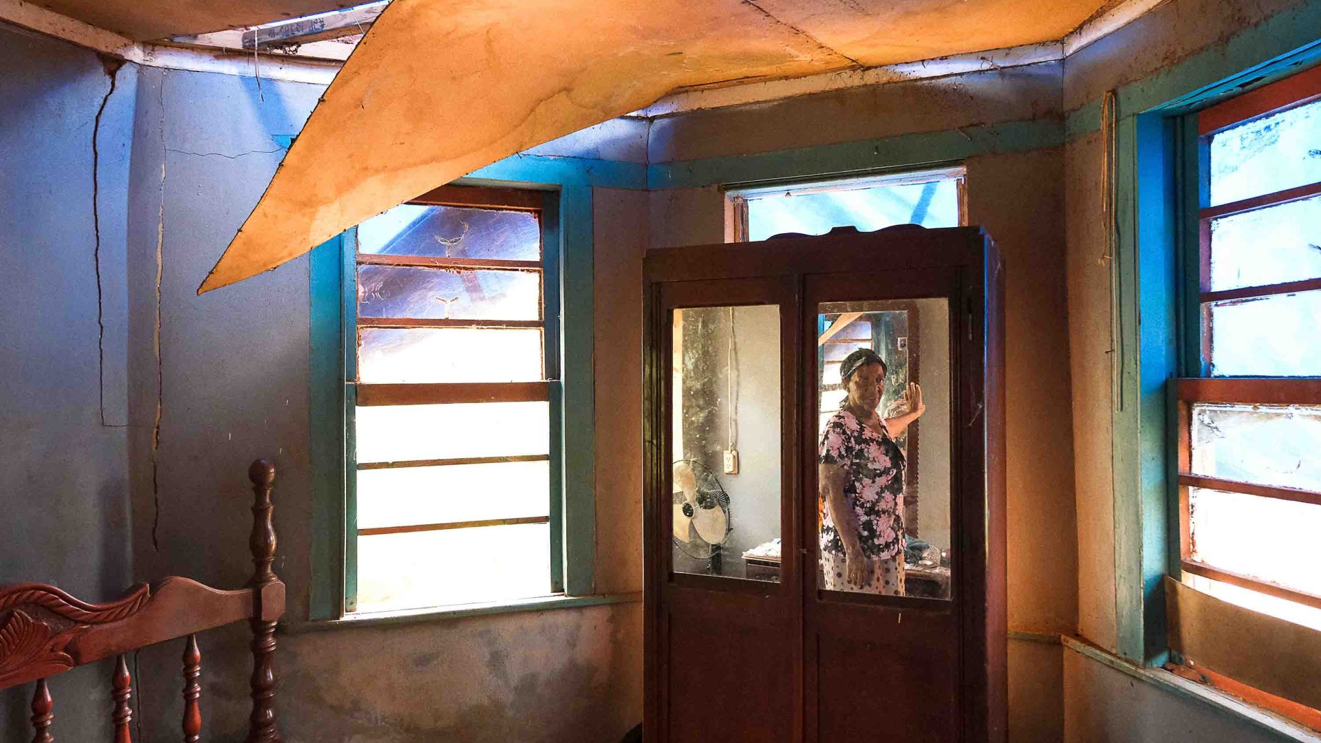 A woman in her home which has no roof.