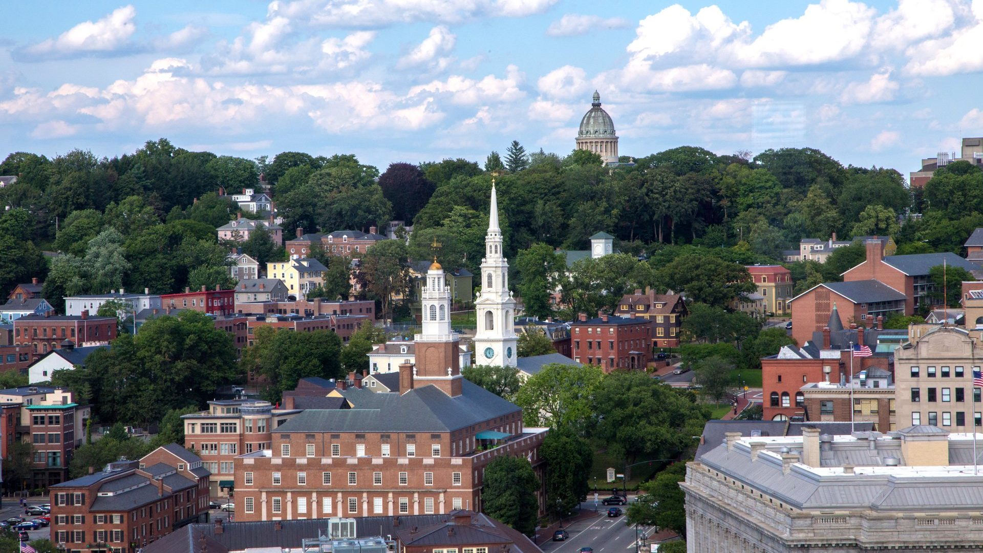 A view of the historic East Side of Providence from a distance, with a white church steeple in the foreground.