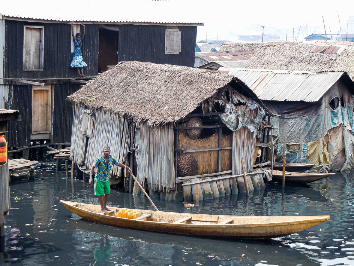 A person paddles past homes in Makoko.