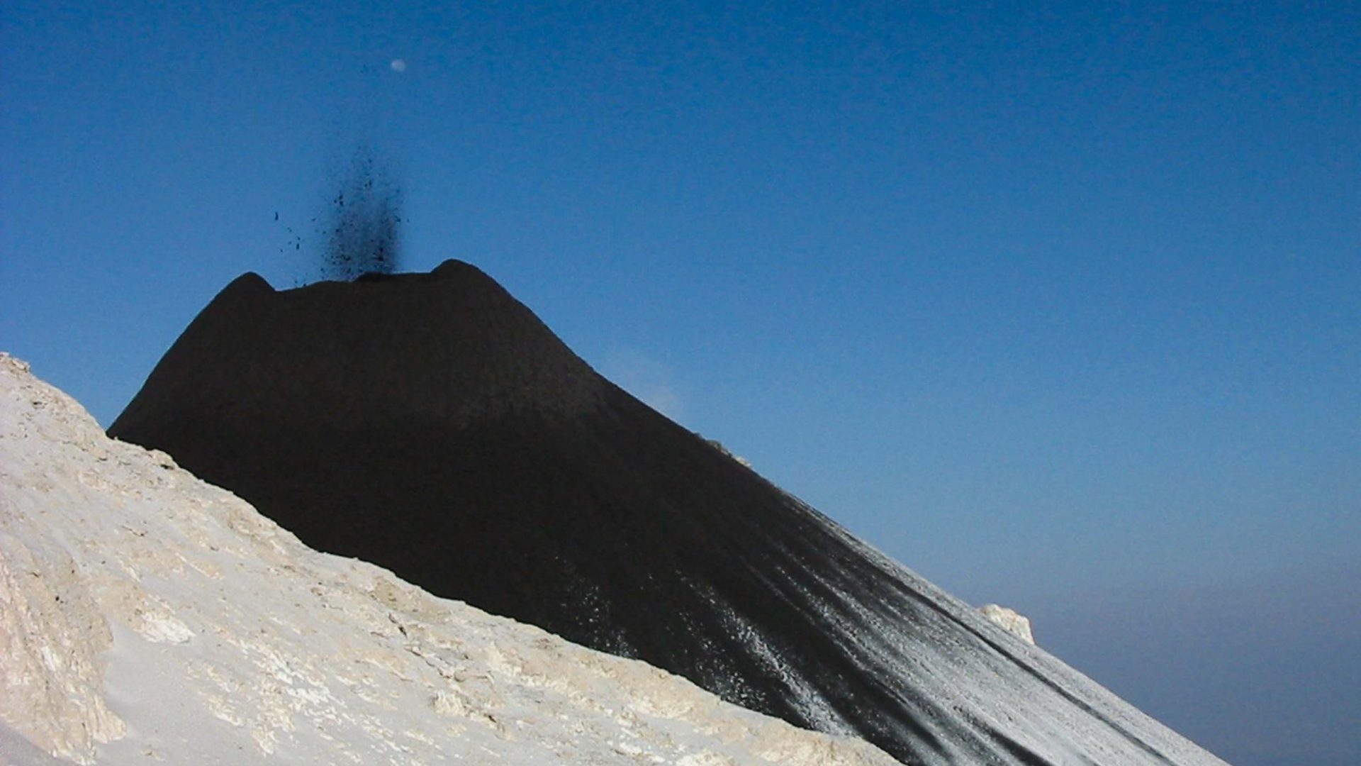 Steam rises from the lava cone.