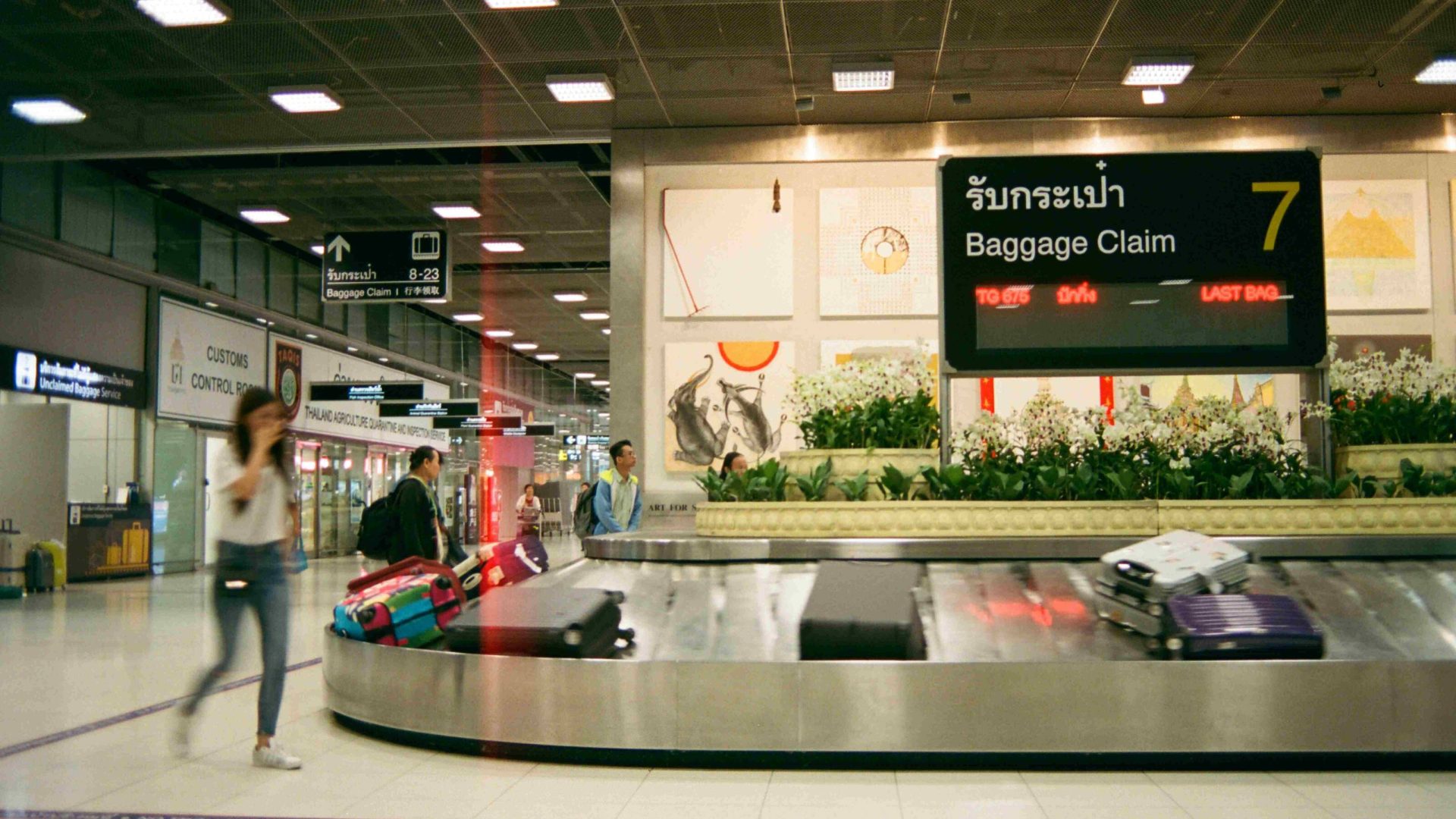 A person waits at baggage claim in an airport.