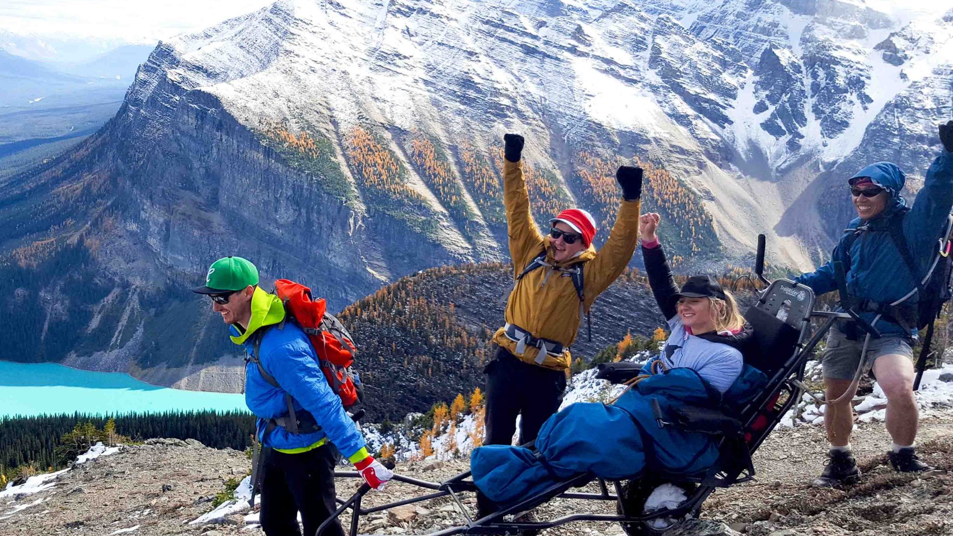 A group of people from Rocky Mountain Adaptive support a disabled traveler to explore the mountains.