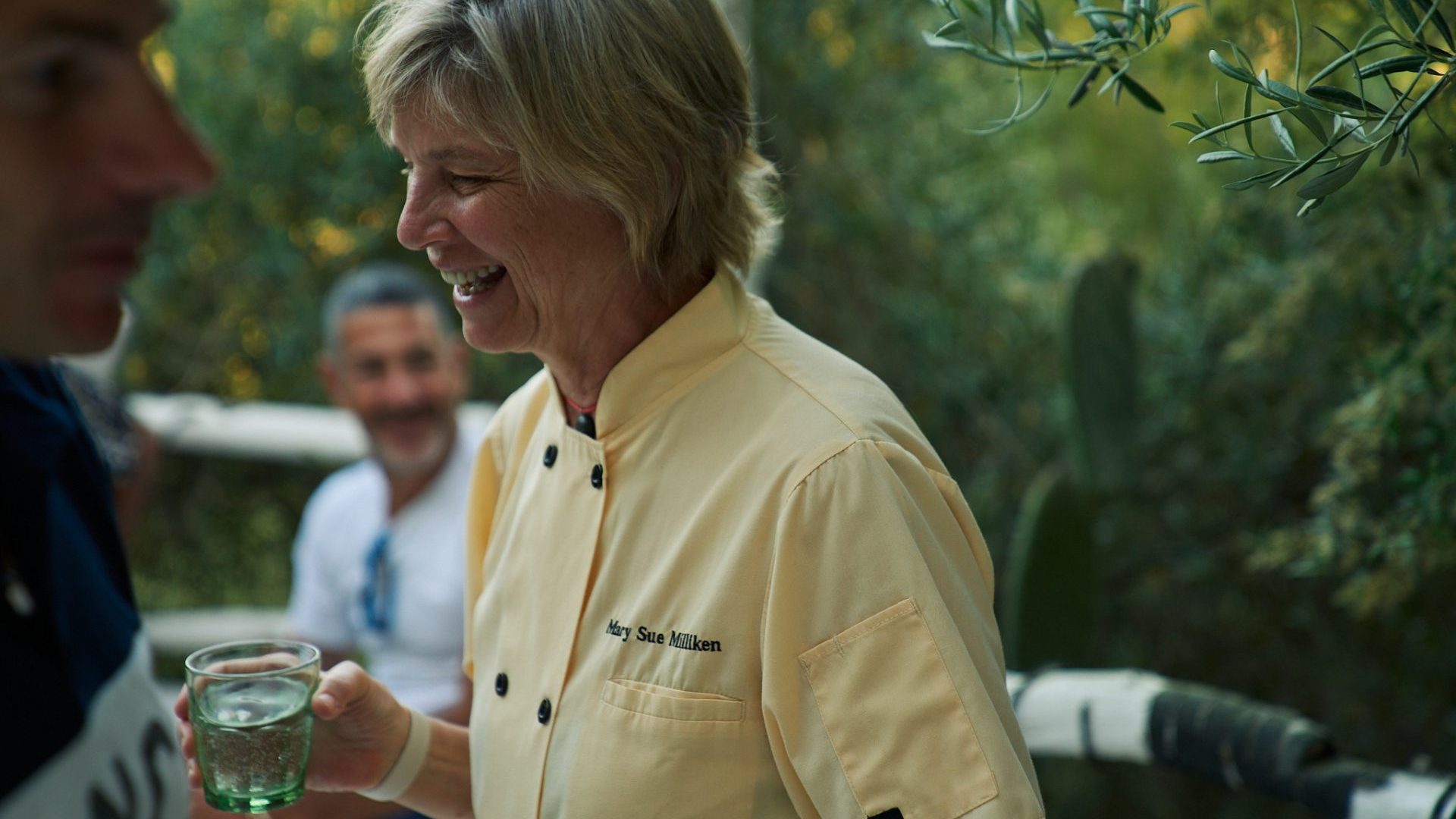 woman wearing yellow chef shirt smailes