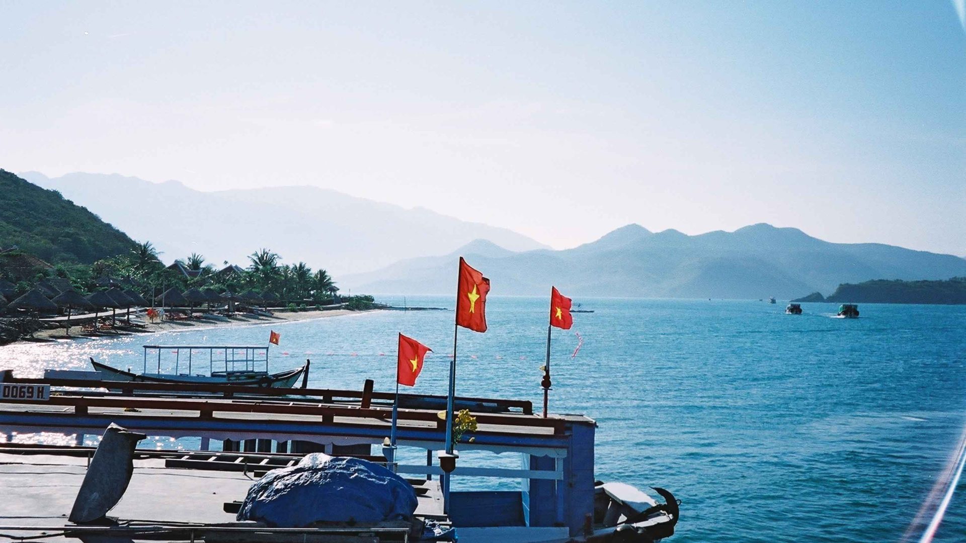 A boat in the water with Vietnamese flags on it.