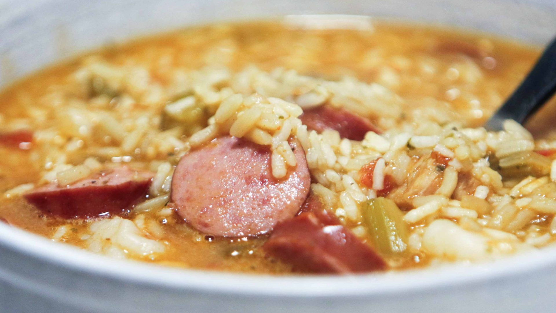 A bowl of stew with rice and meat in it.