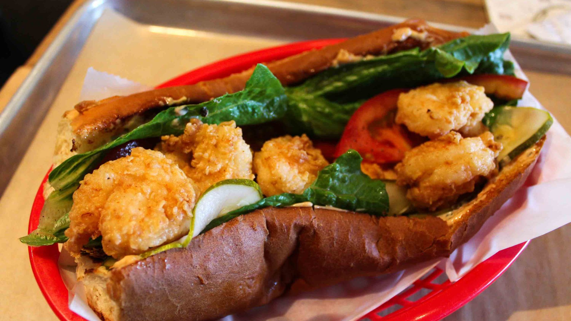 A po'boy sandwich with lettuce, shrimp and tomato.