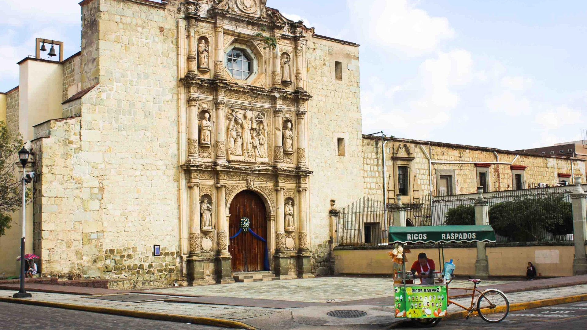 A vendor outside a church in a plaza.