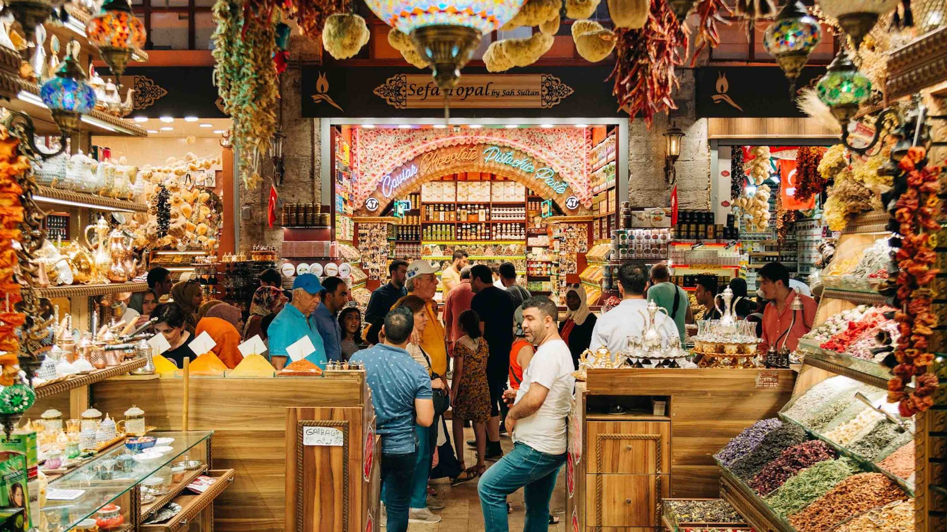 The interior of a colorful market where people are standing around talking.