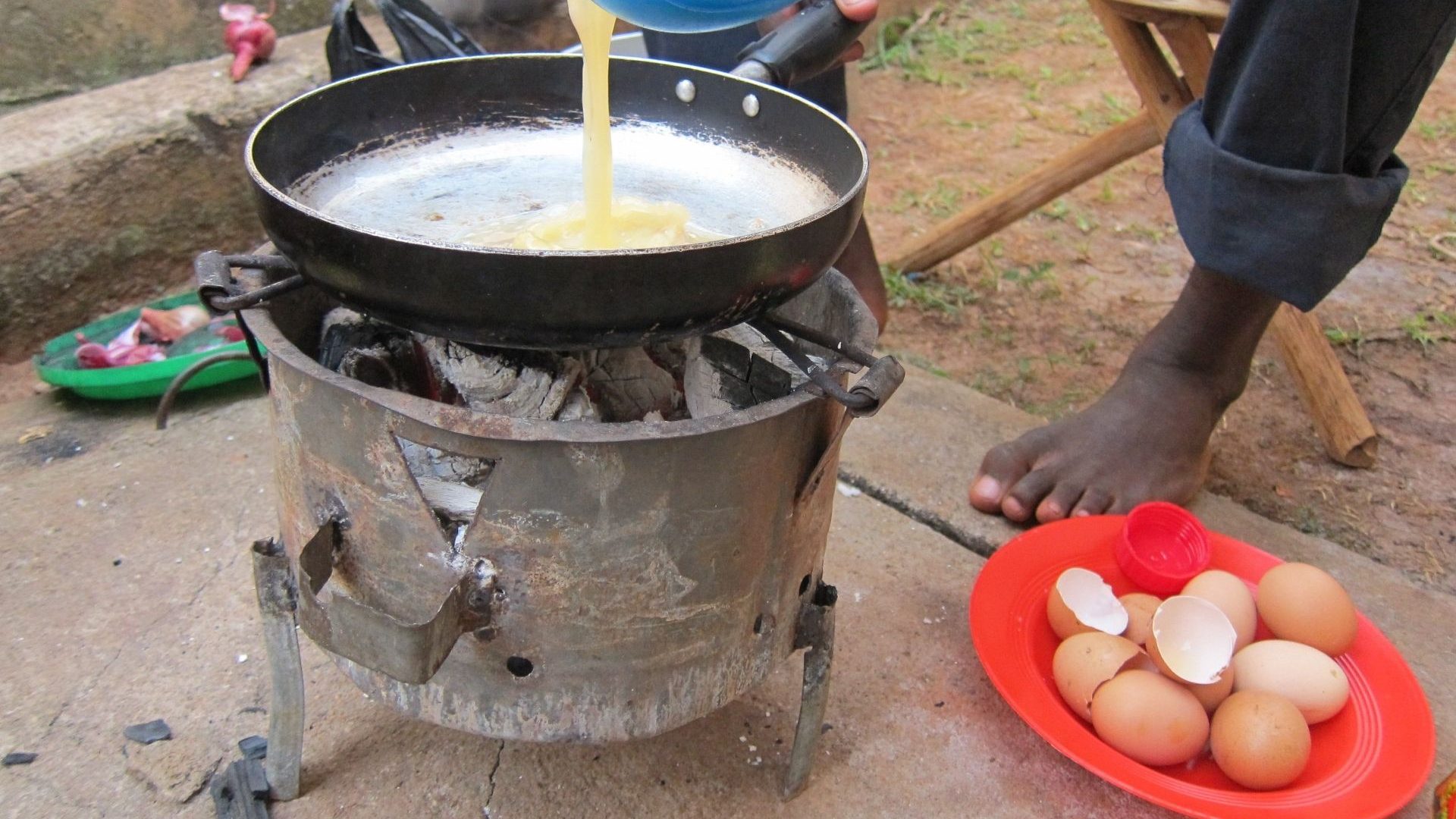 Eggs being cracked a large pan at a street food stand