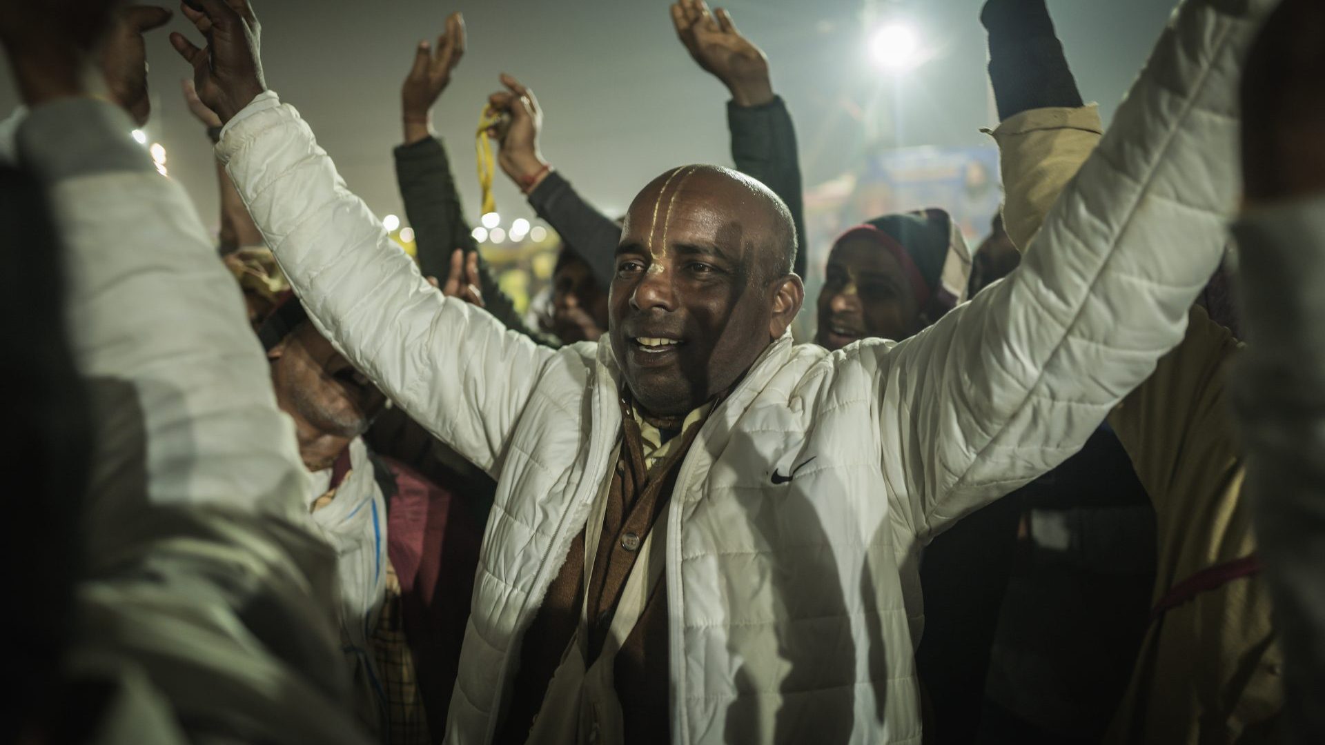 A group of Hare Krishna followers chant with arms in the air