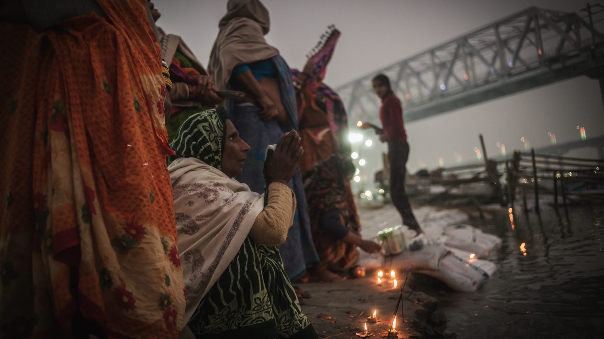 Women pray at the river Ganges