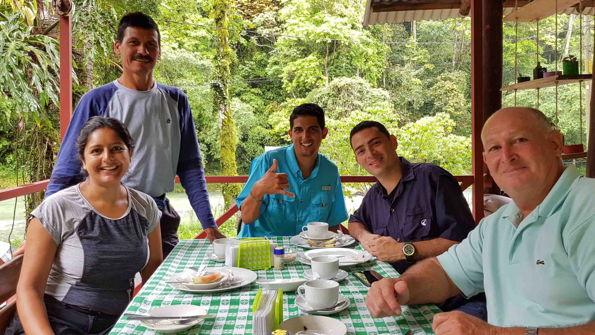 A group of people at a table smile to the camera.